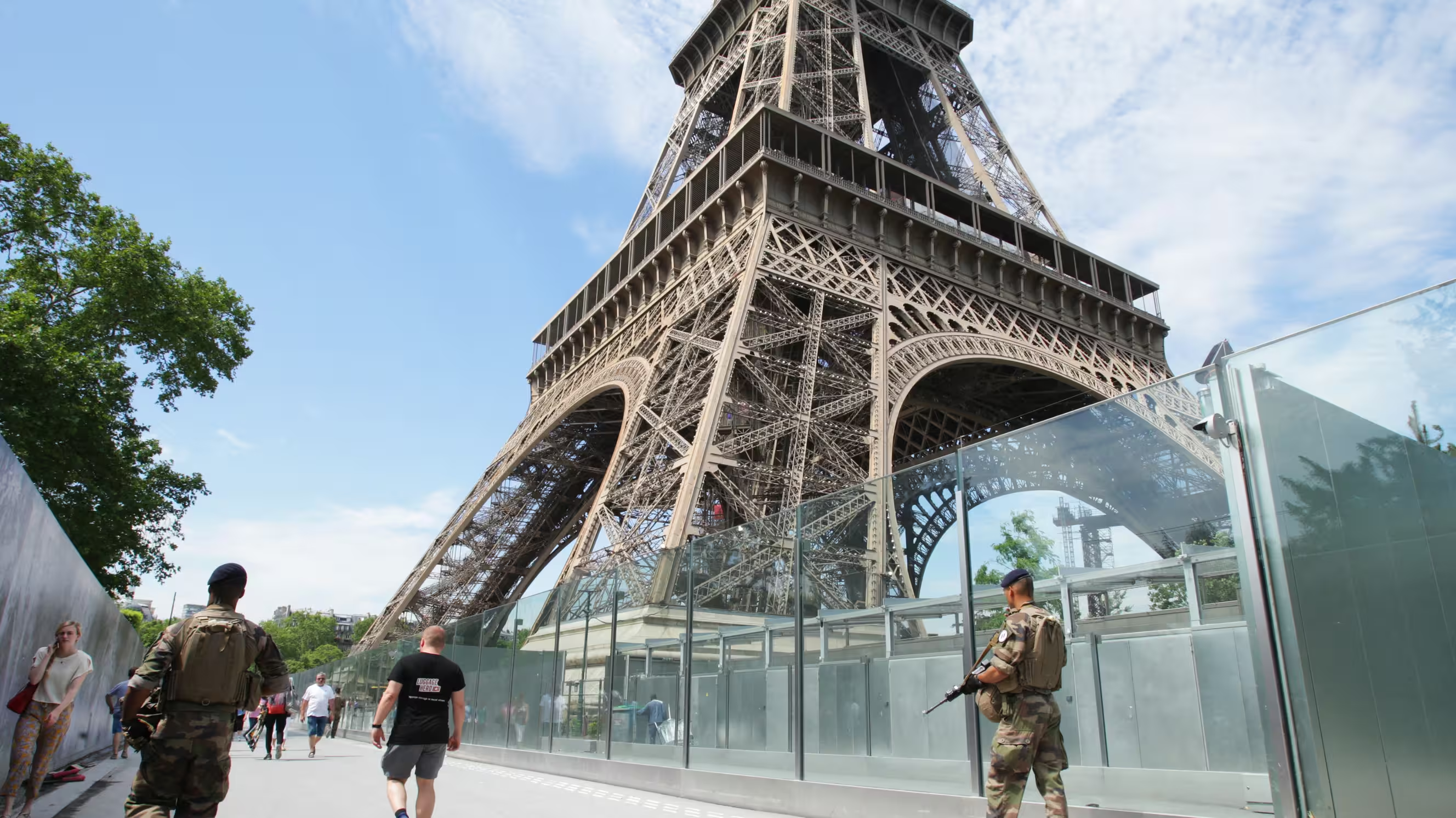 La tour Eiffel avec des barricades translucides et des militaires