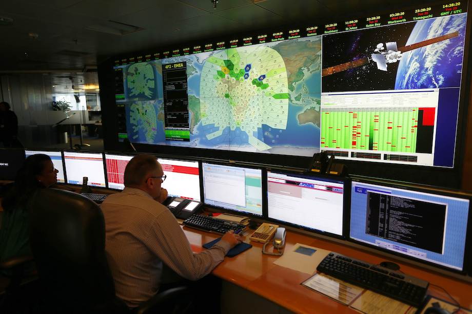 Un membre du personnel de la société de communications par satellite Inmarsat pose devant une section de l'écran montrant le sud de l'océan Indien à l'ouest de l'Australie, à leur siège à Londres le 25 mars 2014